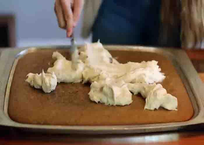 Spreading the cream cheese over the pumpkin cake