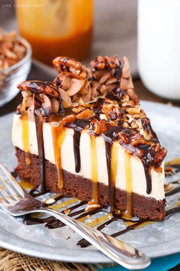 Turtle brownie cheesecake slice with pecans, caramel and chocolate sauce over a dark brownie base on a plate