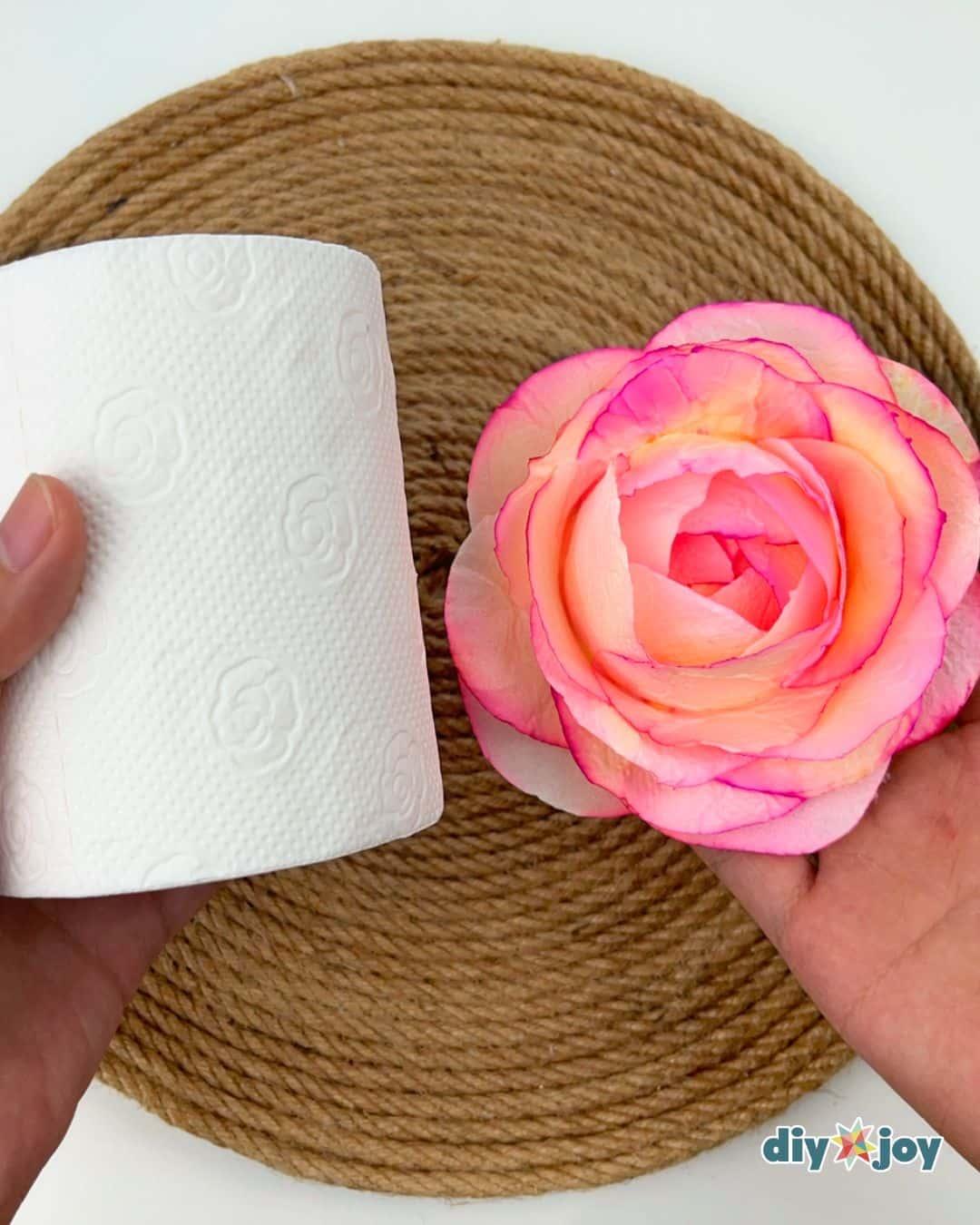 Upcycled flower ideas using toilet paper, soft handmade paper roses in pastel shades grouped on a table