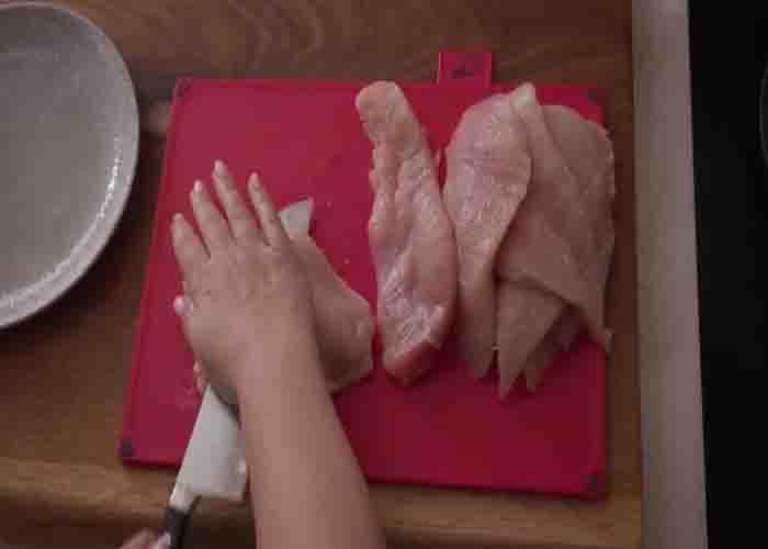 Cutting the chicken horizontally for the crispy baked chicken recipe