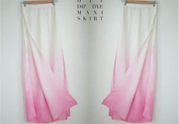 White maxi skirt with deep side splits hung on a curtain rail, the hem dip dyed from cream to bright pink