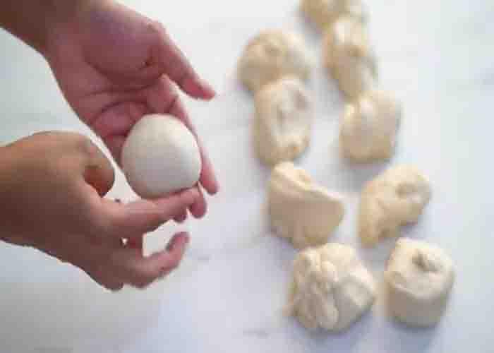 Dividing the dough into equal parts to make the Kaiser rolls