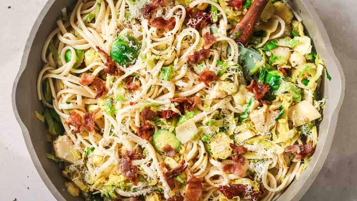Brussels sprouts pasta with bacon, thin sliced sprouts, crumbled bacon and sun dried tomatoes tossed through spaghetti