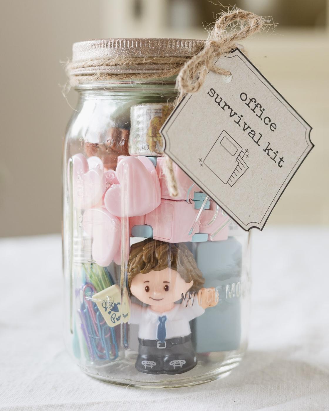 Mason jar packed with miniature office supplies including tiny notebooks, clips and pens as a desk survival kit