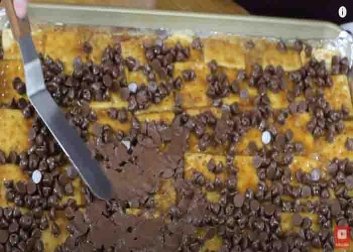 Spreading the chocolate chips over the saltine crackers