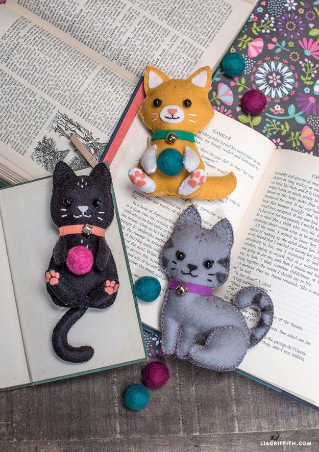 DIY felt craft kittens, three small stitched felt cats in black ginger and grey sitting on open books with wool balls