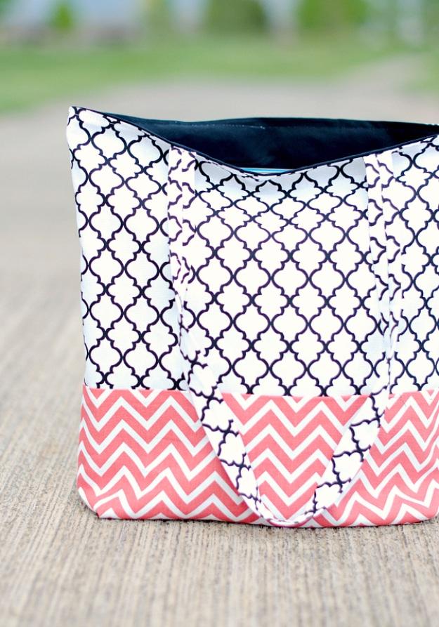 Navy quatrefoil tote bag with a coral chevron band across the bottom, standing open on a wooden deck outdoors