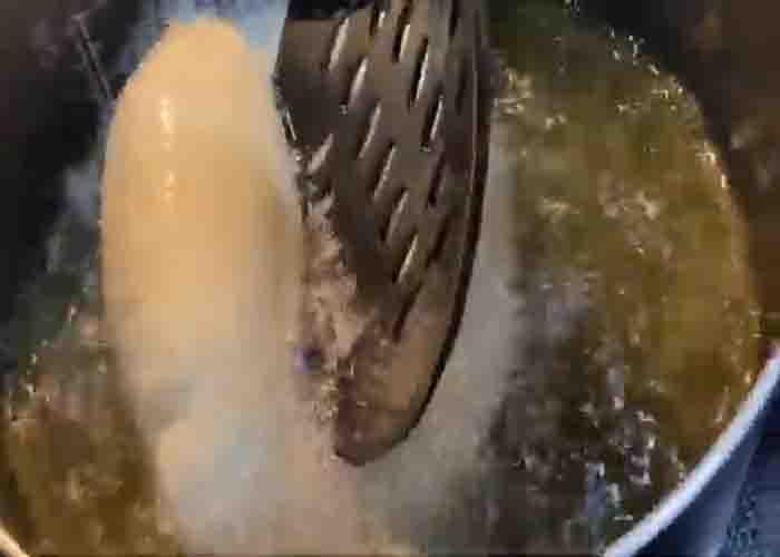 Making the puffy tacos by deep frying them