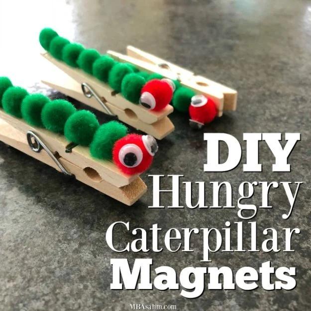 Clothespins covered in green pom poms with red pom pom heads and googly eyes, made as fridge magnets