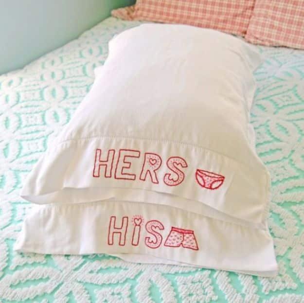 A pair of white pillowcases hand embroidered with his and hers designs, a romantic handmade gift idea