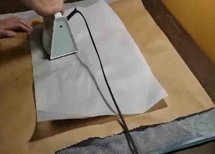 Ironing the plastic bags to turn them into fabric