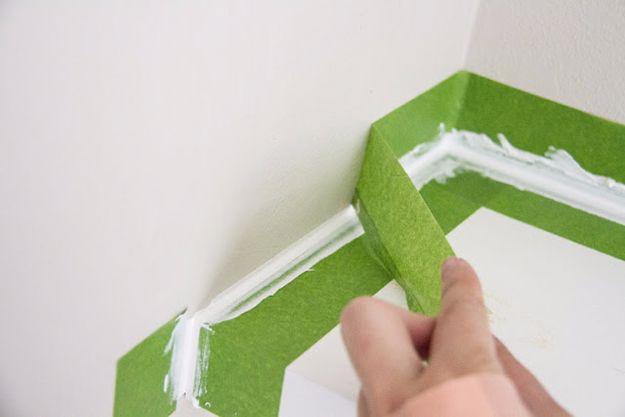 Perfect caulk edge with painter's tape, green tape along a white wall corner with a smoothed caulk bead between