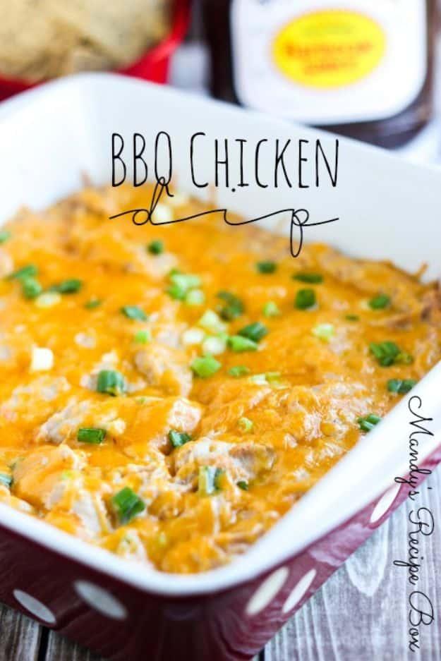 BBQ chicken dip baked until bubbling with melted cheddar and sliced green onions in a red square baking dish