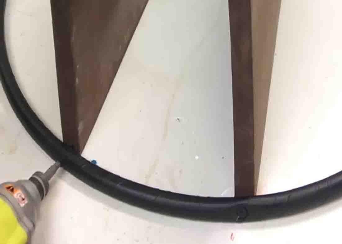 Securing the wood on the hula hoop for the DIY shelf