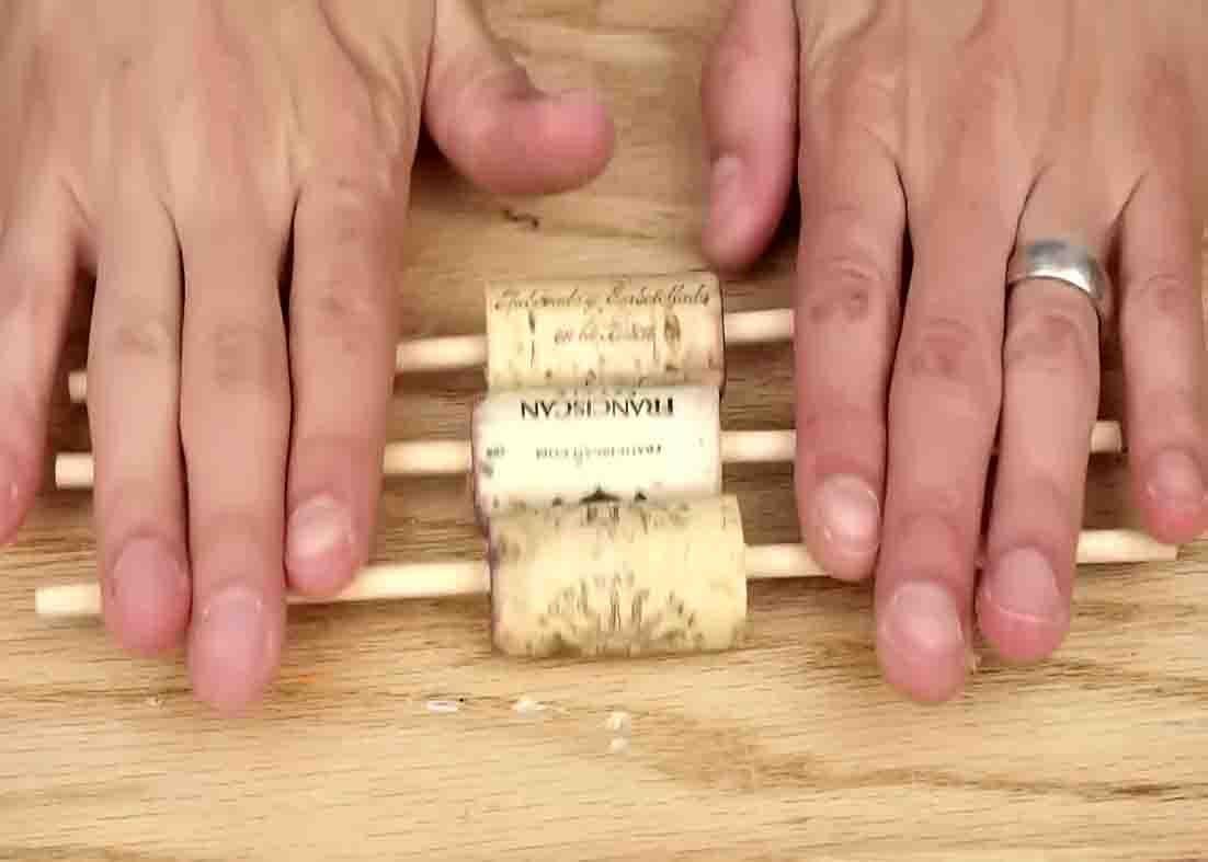 Inserting the dowels to the wine corks for the fishing bobbers