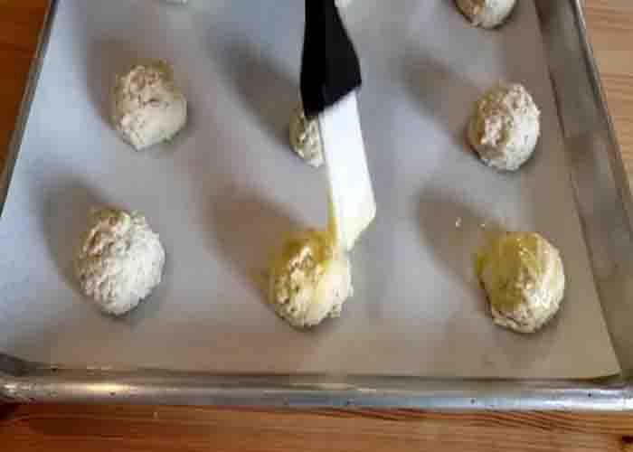 Brushing each lemon cookies with eggwash