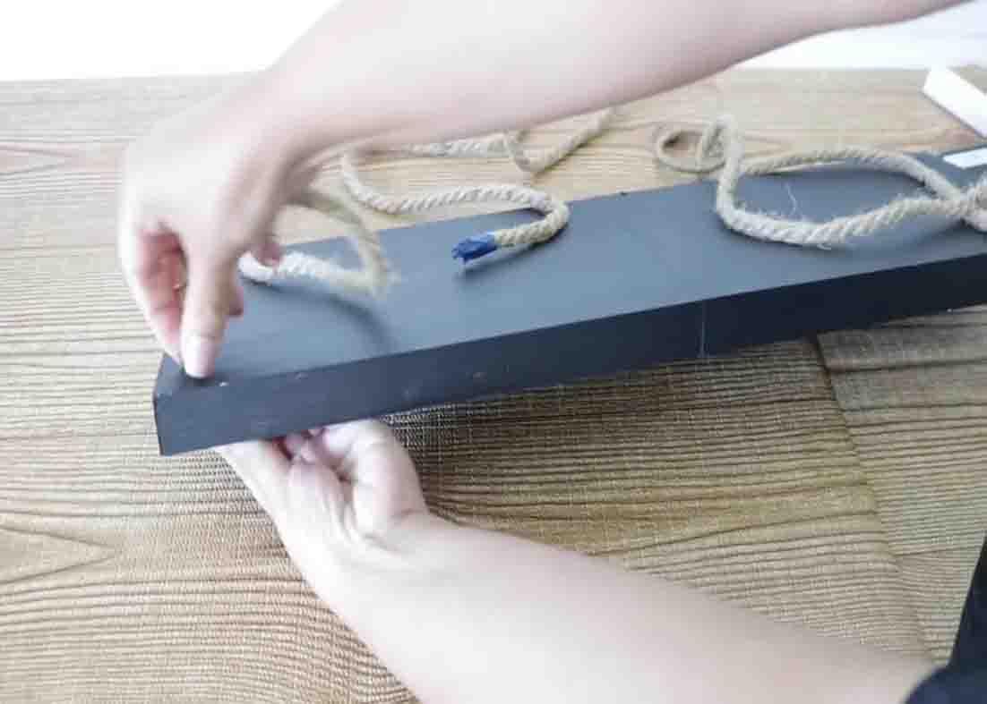 Inserting the ropes to the hanging shelf