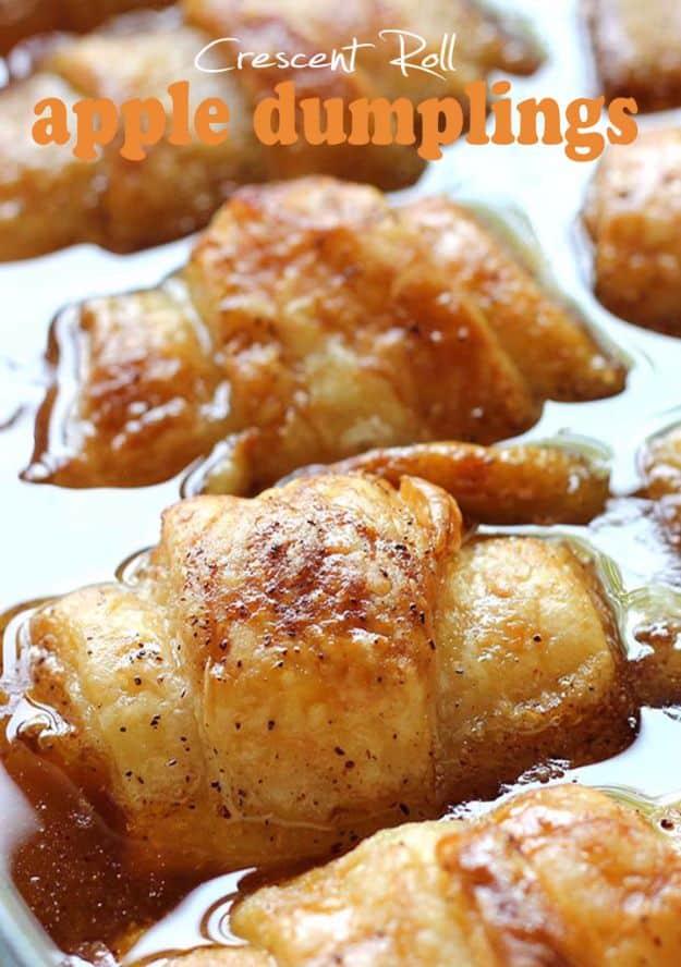 Crescent roll apple dumplings baked in cinnamon brown sugar syrup in a nine by thirteen pan with ice cream