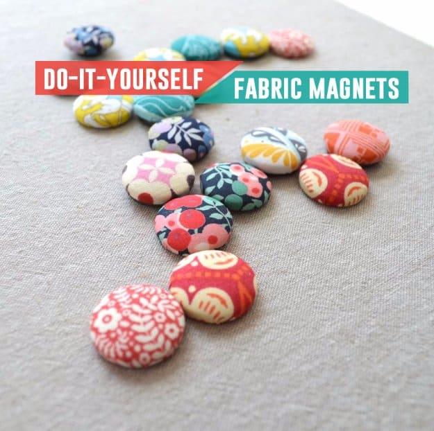 Sixteen fabric covered button magnets in bright floral prints scattered on linen, with a typeset DIY fabric magnets banner