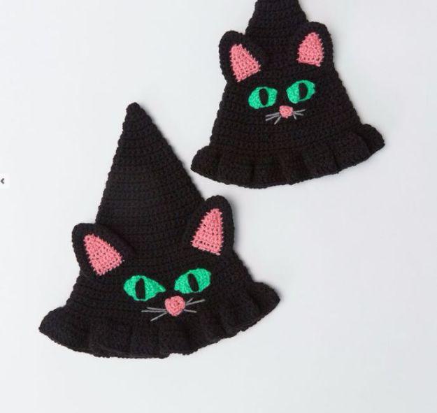 Witchy cat hat crochet pattern, two black crochet witch hats with pink ears green cat eyes and ruffled brims