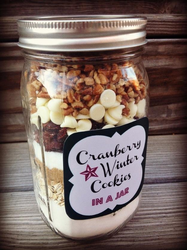 Quart mason jar of cranberry winter cookie mix with white chocolate chips, pecans and a printed label