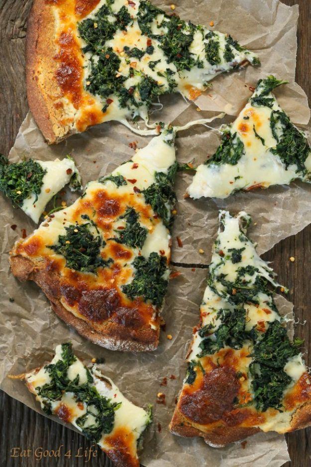 Sliced roasted garlic spinach white pizza with mozzarella and chili flakes on brown baking parchment