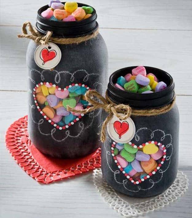 Chalkboard painted mason jars with tiny heart windows showing the candy hearts packed inside as a homemade gift