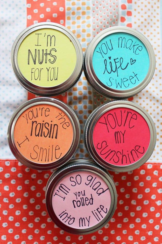 Mason jar filled with snacks and a folded love note pressed against the glass as a Valentine gift to make at home