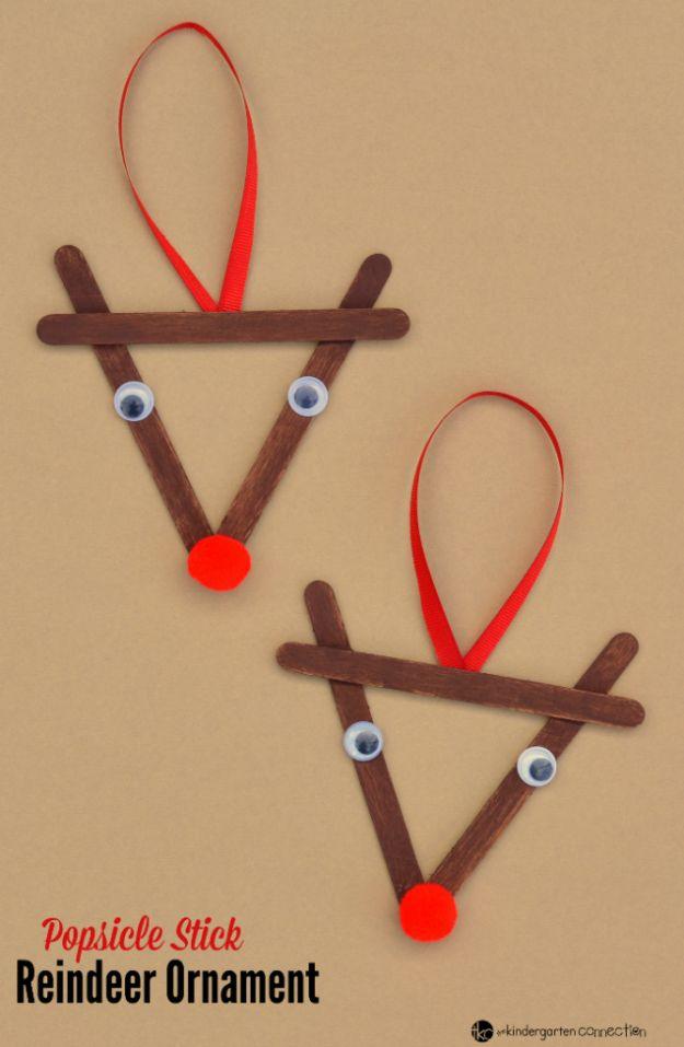 Two popsicle stick reindeer ornaments painted brown with googly eyes, red pom pom noses and red ribbon loops