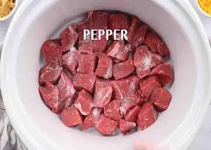 Adding the stew meat to the slow cooker
