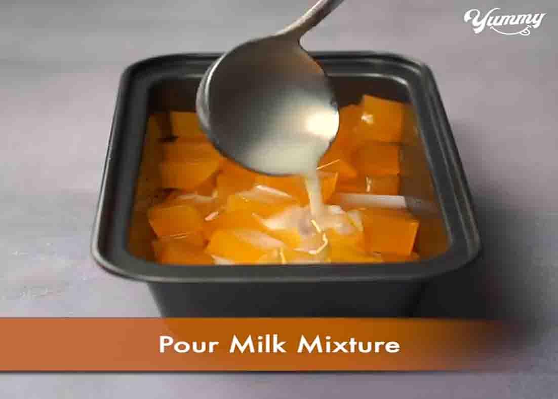 Adding the milk mixture over the orange jello pieces