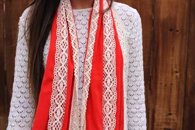 Lace scarf, a woman wearing a long red scarf with two vertical cream lace bands over a white knit cardigan