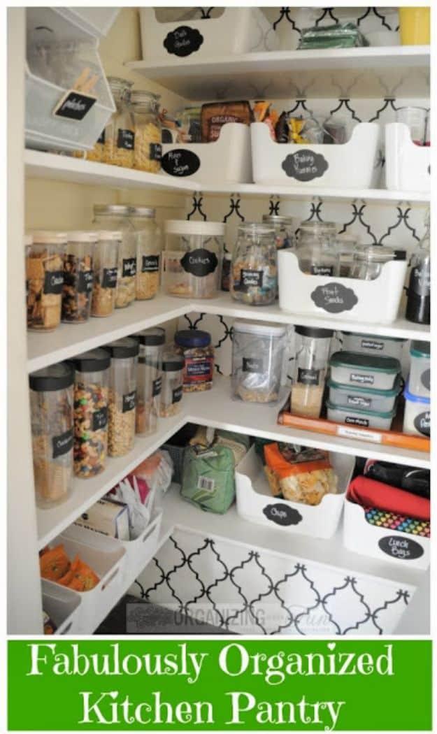Patterned wallpaper pantry with clear jars, glass bottles, white wire door racks and cardboard chalkboard labels
