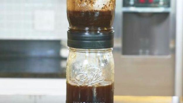 DIY cold brew in a mason jar, a Ball jar of dark cold brew coffee with a screw on filter lid standing on a kitchen counter