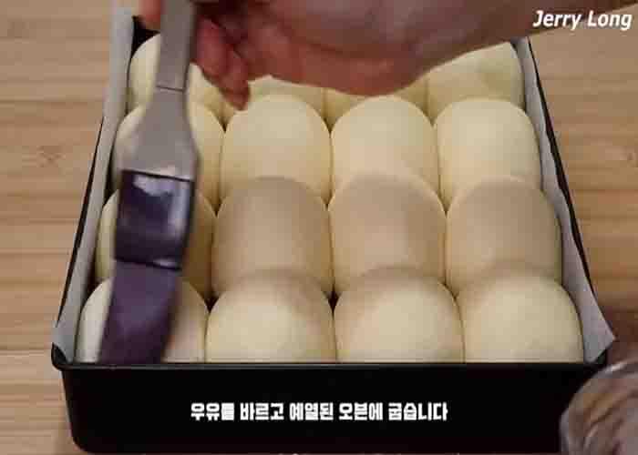 Brushing the dough top with milk before baking