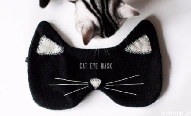 DIY cat eye mask, a black fleece sleep mask shaped as a cat face with white ear tips and stitched whiskers on white