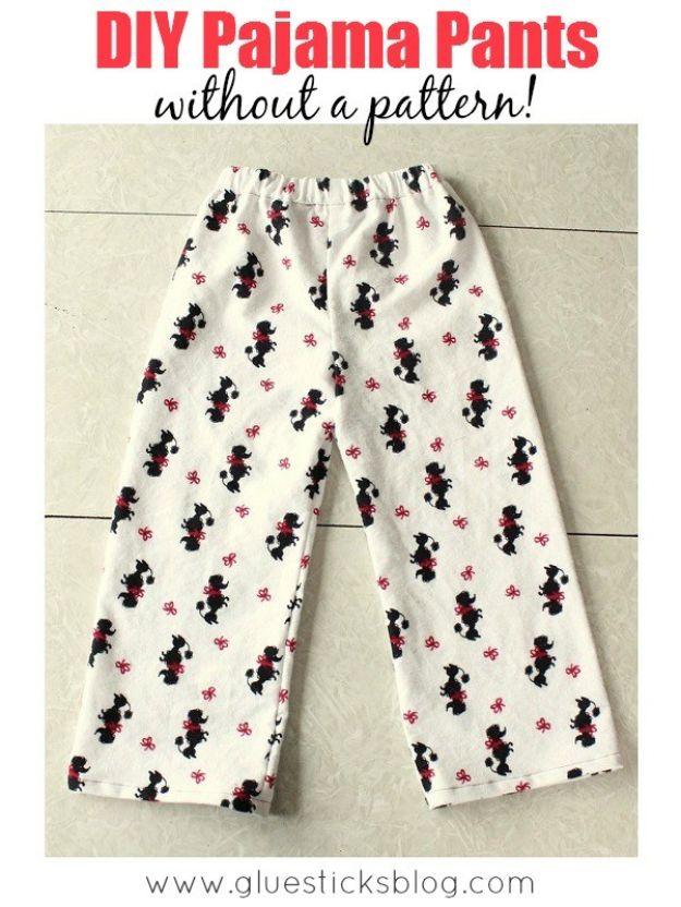 Cream flannel pajama pants printed with small black figures, laid flat on a white painted wooden surface