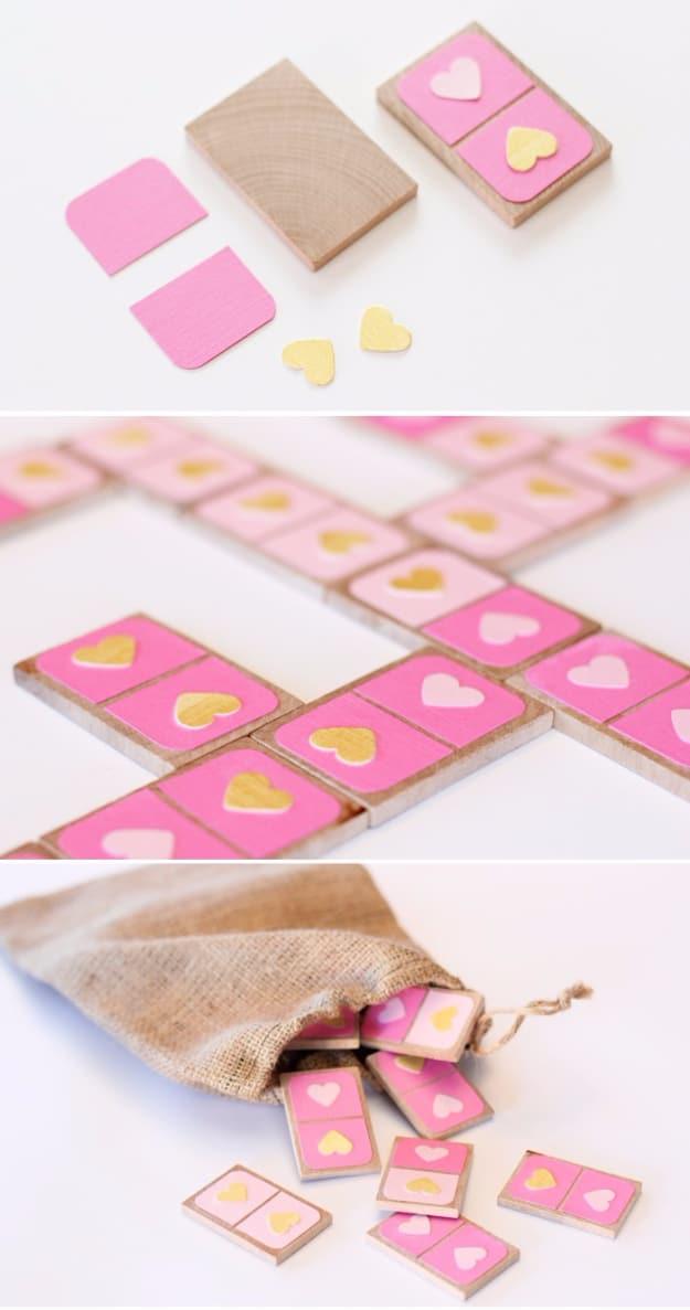 Set of dominoes painted in pink and red Valentine colors laid out on a table as a handmade gift for a handmade gift