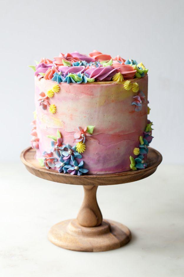 Birthday cake with pastel watercolor buttercream sides and a sprinkle gradient rising from the base recipe for a celebration