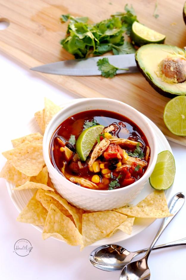 Instant Pot chicken tortilla soup with shredded chicken, black beans, corn, tortilla strips and lime