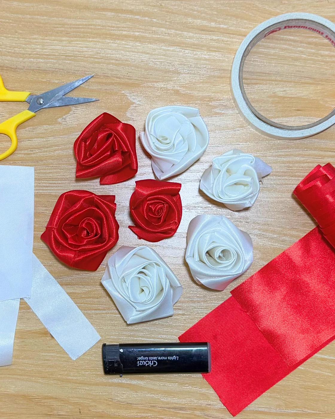 Homemade ribbon rose shown close up, the folded satin petals glued and layered around the center of the flower