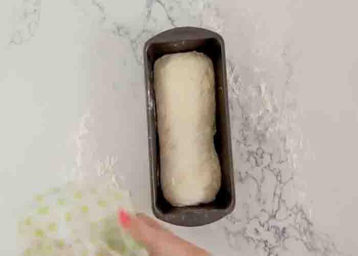 Placing the homemade sandwich bread to a greased loaf pan