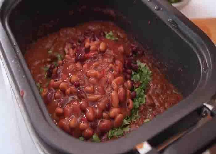 Adding the kidney beans to the slow cooker beef and pork