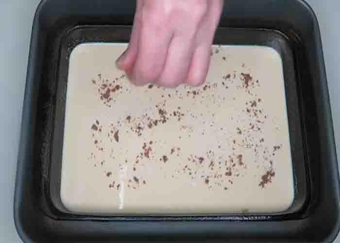 Sprinkling some ground nutmeg over the custard dessert