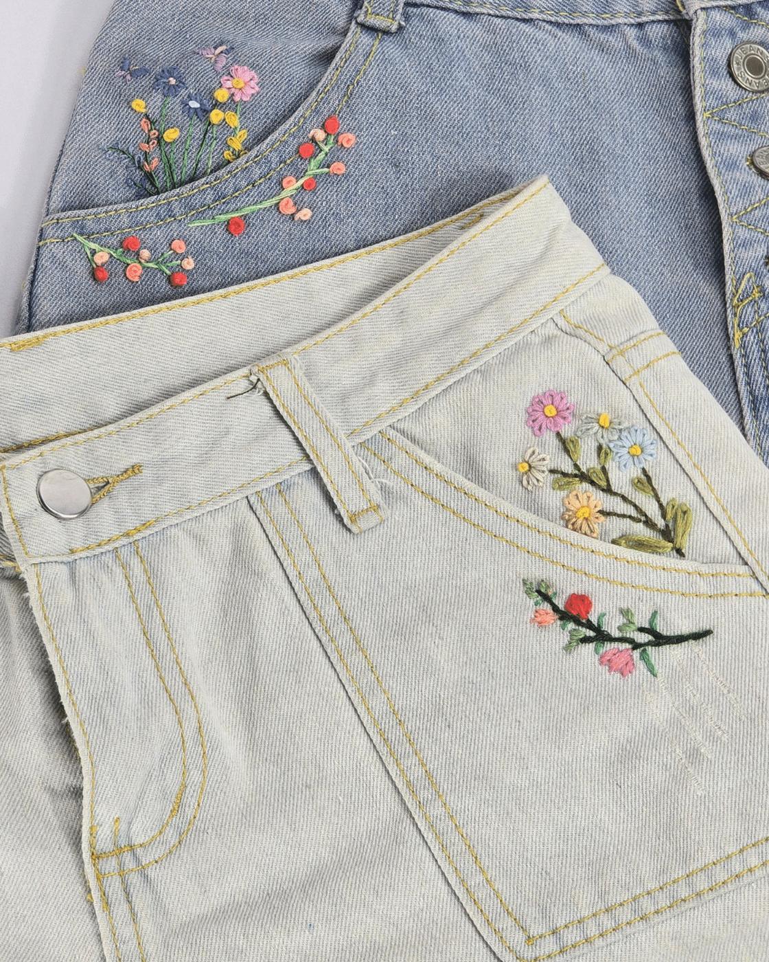 Flower embroidery design for jeans, a finished floral pattern stitched in bright floss across blue denim