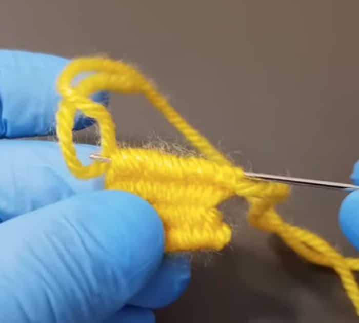 Make a yarn flower out of yarn and a fork
