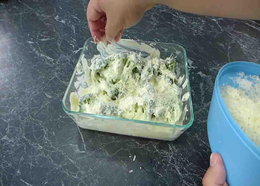Topping the broccoli casserole with parmesan cheese