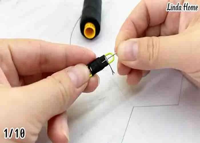Wrapping a thread and inserting a needle to a paper clip to make a bring-along sewing kit