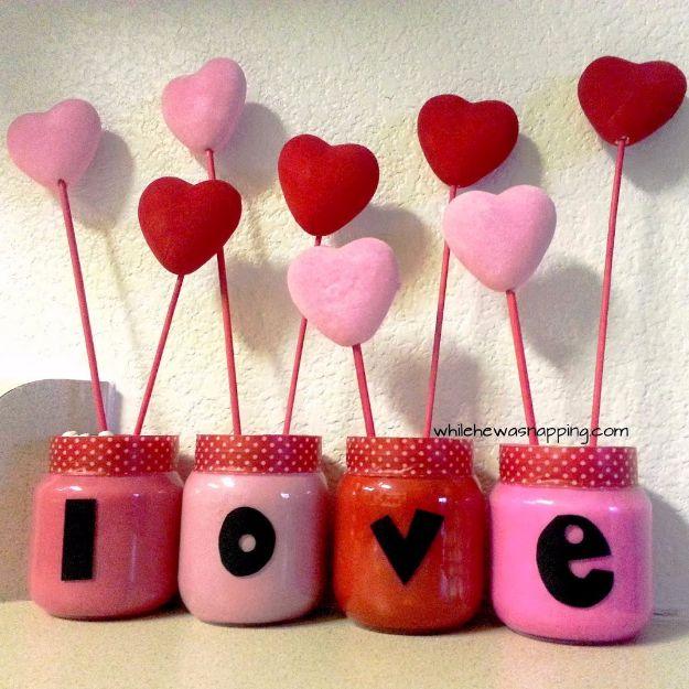 Four small terracotta pots painted with the letters L O V E and planted, a cute DIY Valentine gift idea
