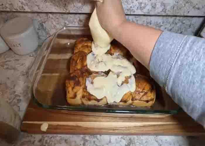 Adding the cream cheese mixture over each Hawaiian rolls